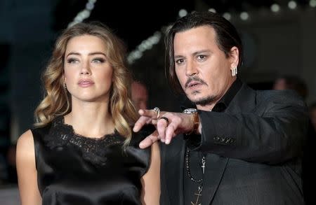 Cast member Johnny Depp and his actress wife Amber Heard arrive for the premiere of the British film "Black Mass" in London, Britain October 11, 2015. REUTERS/Suzanne Plunkett/Files