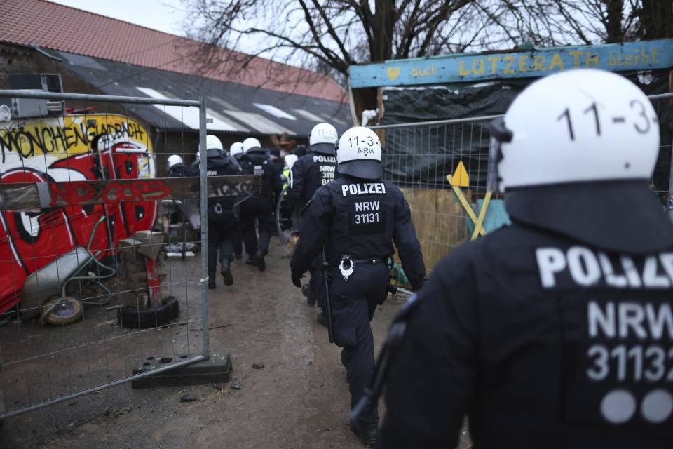 Police officers enter a camp of climate protestors at the village Luetzerath near Erkelenz, Germany, Wednesday, Jan. 11, 2023. Police have entered the condemned village in, launching an effort to evict activists holed up at the site in an effort to prevent its demolition to make way for the expansion of a coal mine. (Rolf Vennenbernd/dpa via AP)