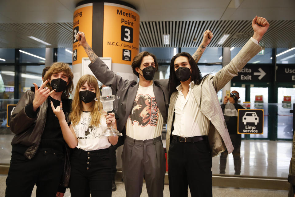 From left, Thomas Raggi, Victoria De Angelis, Damiano David, and Ethan Torchio, of Italian band Maneskin, pose for photographers upon their arrival at Rome's Fiumicino airport, Sunday, May 23, 2021. The glam rock band who got their start busking on Rome's main shopping drag won the Eurovision Song Contest Saturday and brought next year's competition back to the place where Europe's song contests began. (AP Photo/Alessandra Tarantino)