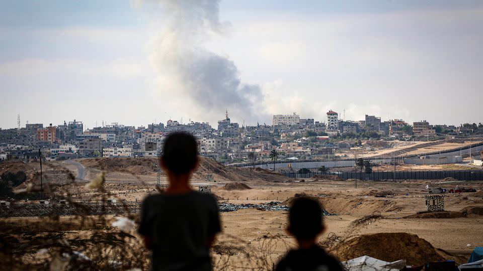 Boys watch smoke billowing during Israeli strikes east of Rafah in the southern Gaza Strip on May 13, 2024. - Stringer/AFP/Getty Images