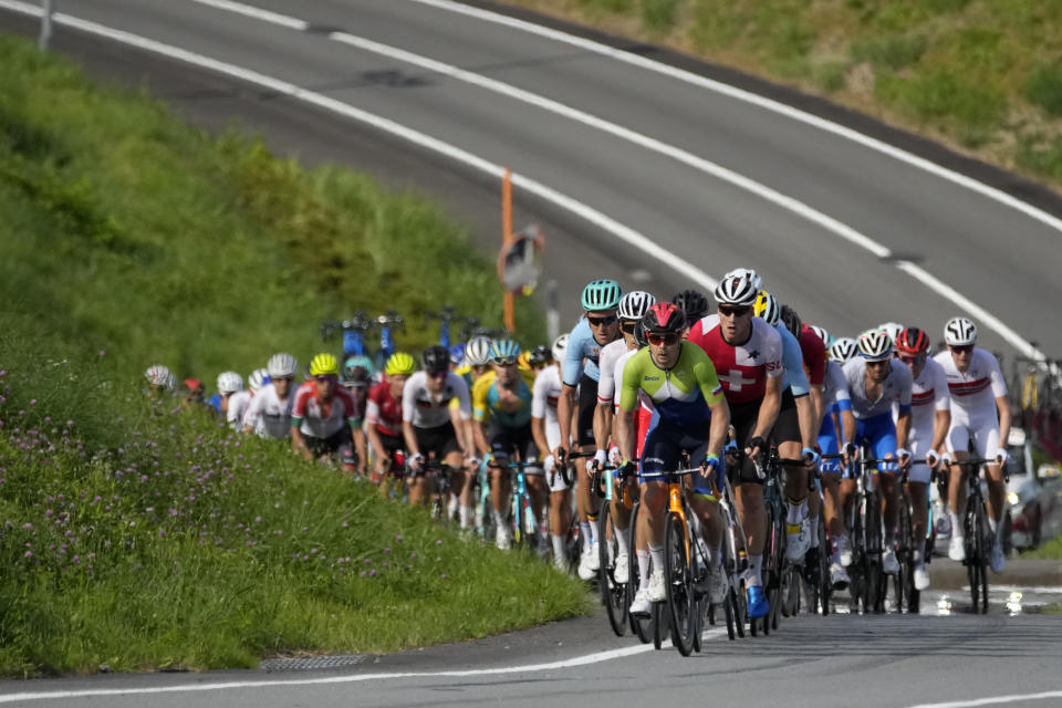The peloton climbs during the men's cycling road race at the 2020 Summer Olympics, Saturday, July 24, 2021, in Oyama, Japan. (AP Photo/Christophe Ena)
