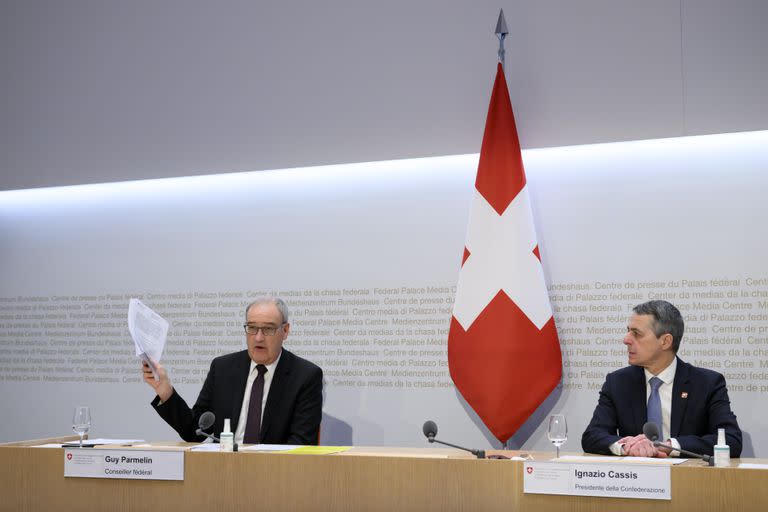 El miembro del consejo federal suizo Guy Parmelin (i) con el presidente del consejo Ignazio Cassis en una reunión del Consejo Federal en Berna, Suiza, el 25 de febrero del 2022. (Anthony Anex/Keystone via AP)