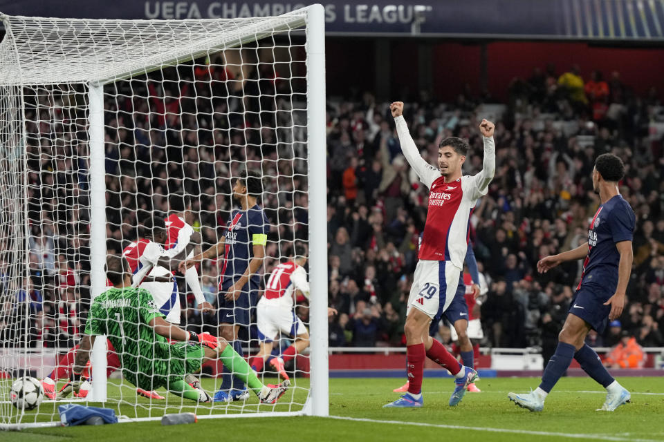 Arsenal's Kai Havertz, center, celebrates after teammate Bukayo Saka scored their side's second goal during a Champions League opening phase soccer match between Arsenal FC and Paris Saint-Germain at Arsenal stadium in London, England, Tuesday, Oct. 1, 2024. (AP Photo/Alastair Grant)