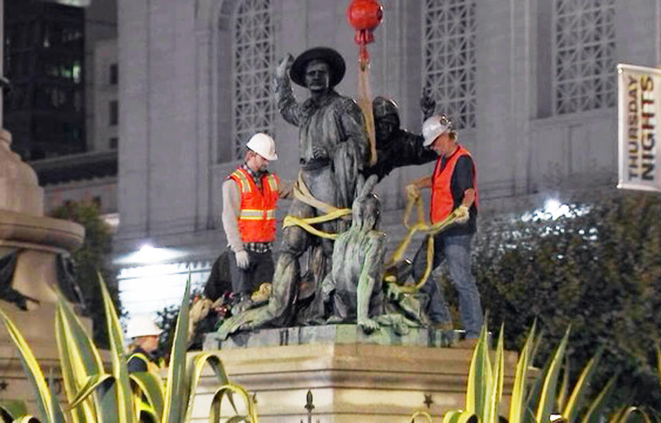 This photo from video provided by KTVU-TV shows crews removing a statue that some have called racist and demeaning to indigenous people, near City Hall in San Francisco early in the morning of Friday, Sept. 14, 2018. The statue depicts a Native American at the feet of a Spanish cowboy and a Catholic missionary, part of a group of statues depicting the founding of California. A San Francisco board voted unanimously on Wednesday to remove it. (KTVU-TV via AP)