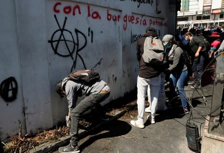 People clean debris from the streets in the aftermath of the last days' protests in Quito