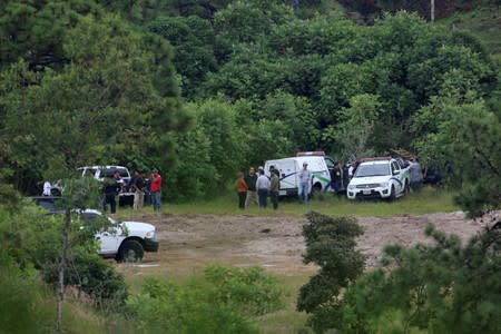 Forensic vehicles and government officials are seen near a clandestine grave while resuming the search for human remains after authorities found bodies packed in plastic bags, in the municipality of Zapopan