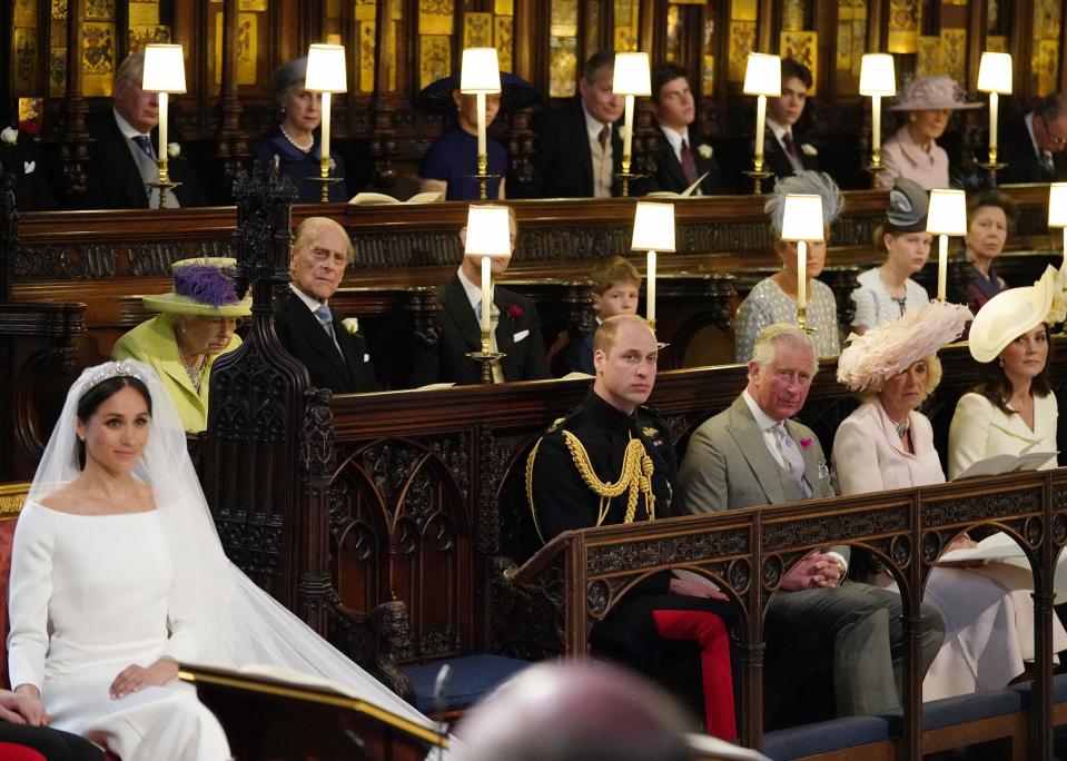 Meghan Markle (L) in St George's Chapel, Windsor Castle for her wedding to Britain's Prince Harry, Duke of Sussex, watched by (middle row L-R) Britain's Queen Elizabeth II, Britain's Prince Philip, Prince William, Duke of Cambridge, Britain's Prince Charles, Prince of Wales, Britain's Camilla, Duchess of Cornwall, Duchess of Britain's Catherine, Duchess of Cambridge, and Britain's Prince Andrew, Duke of York