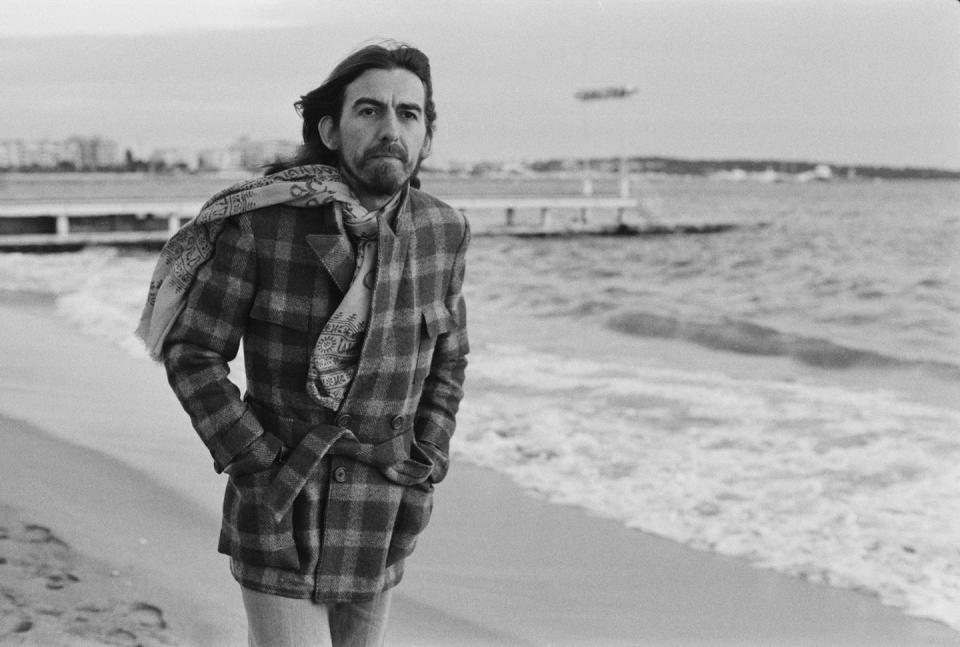 <p>George Harrison strolls along the beach in Cannes, France in 1976. </p>