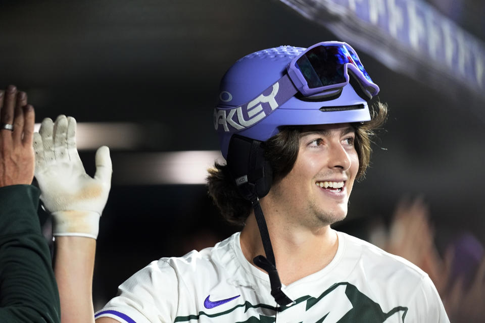 Colorado Rockies' Michael Toglia is congratulated as he returns to the dugout after hitting a grand slam off Pittsburgh Pirates relief pitcher Dennis Santana during the eighth inning of a baseball game Saturday, June 15, 2024, in Denver. (AP Photo/David Zalubowski)