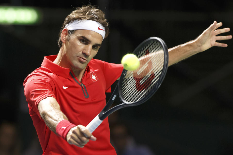 El suizo Roger Federer hace una devolución al kazajo Andrey Golubev, durante un encuentro de cuartos de final de la Copa Davis en Ginebra, el domingo 6 de abril de 2014 (AP Foto / Keystone, Salvatore Di Nolfi)