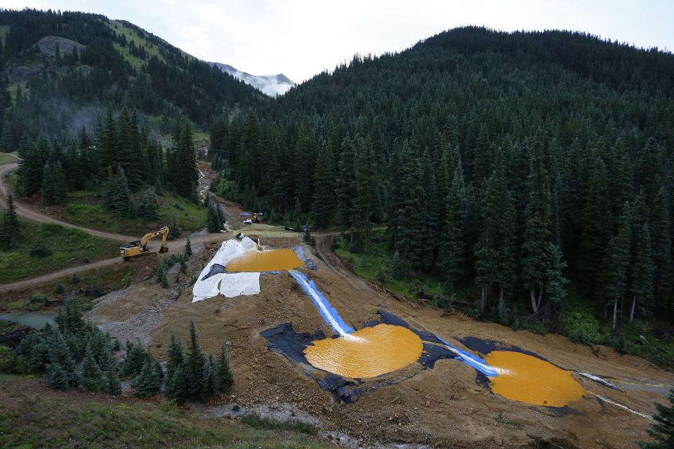 FILE - Wastewater flows through a series of retention ponds built to contain and filter out heavy metals and chemicals from the Gold King Mine in Silverton, Colo,. on Aug. 12, 2015. Colorado, the U.S. government and a gold mining company have agreed to resolve a longstanding dispute over who’s responsible for cleanup at a Superfund site that was established after a massive 2015 spill of hazardous mine waste. The proposed settlement announced Friday, Jan. 21, 2022, would direct $90 million to cleanup at the Bonita Peak Mining District Superfund site, according to the U.S. Environmental Protection Agency and Denver-based Sunnyside Gold Corp.(AP Photo/Brennan Linsley, File)
