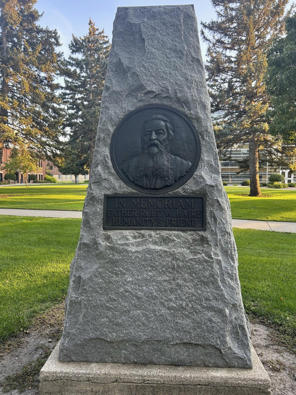 In this photo provided by Tom Heinz, a monument dedicated to the Rev. Robert W. Haire, calling him "humanity's friend," stands on Northern State University campus in Aberdeen, South Dakota, on Wednesday, Sept. 13, 2023. The socialist Catholic priest and direct democracy advocate served on the South Dakota Board of Regents and was influential in establishing the university. (Courtesy Tom Heinz via AP)