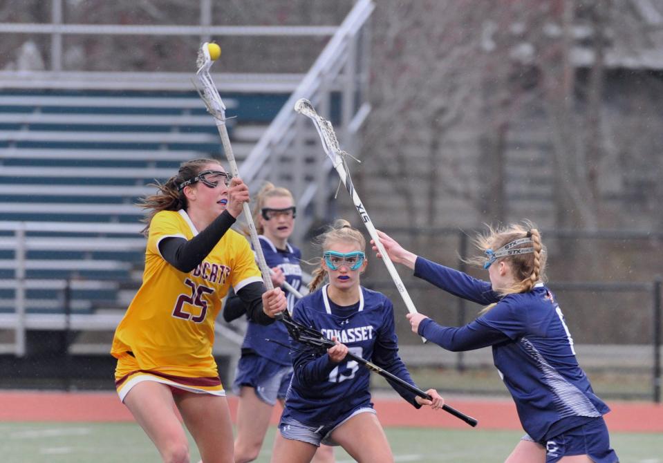 Weymouth's Megan Doyle, left, passes as Cohasset's Rorie Newman, left, and Kylie Newman, right, defend during girls lacrosse at Weymouth High School, Friday, March 31, 2023.