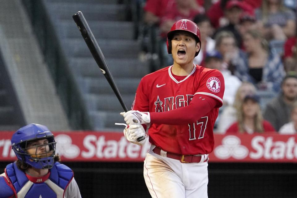 Angels' Shohei Ohtani yells a warning after hitting a foul ball toward a camera.