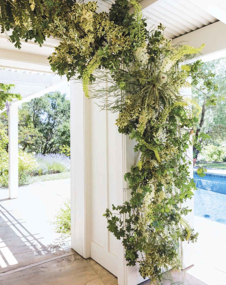 This photo provided by Ten Speed Press shows a floral arch featured in the book "Seasonal Flower Arranging: Fill Your Home with Blooms, Branches, and Foraged Materials All Year Round" by Ariella Chezar. As environmental awareness grows, many couples are saying "I do" to Zero-Waste weddings. They're trying to cut back on trash _ everything from floral design and dresses to invitations and food. (Erin Kunkel/Ten Speed Press via AP)