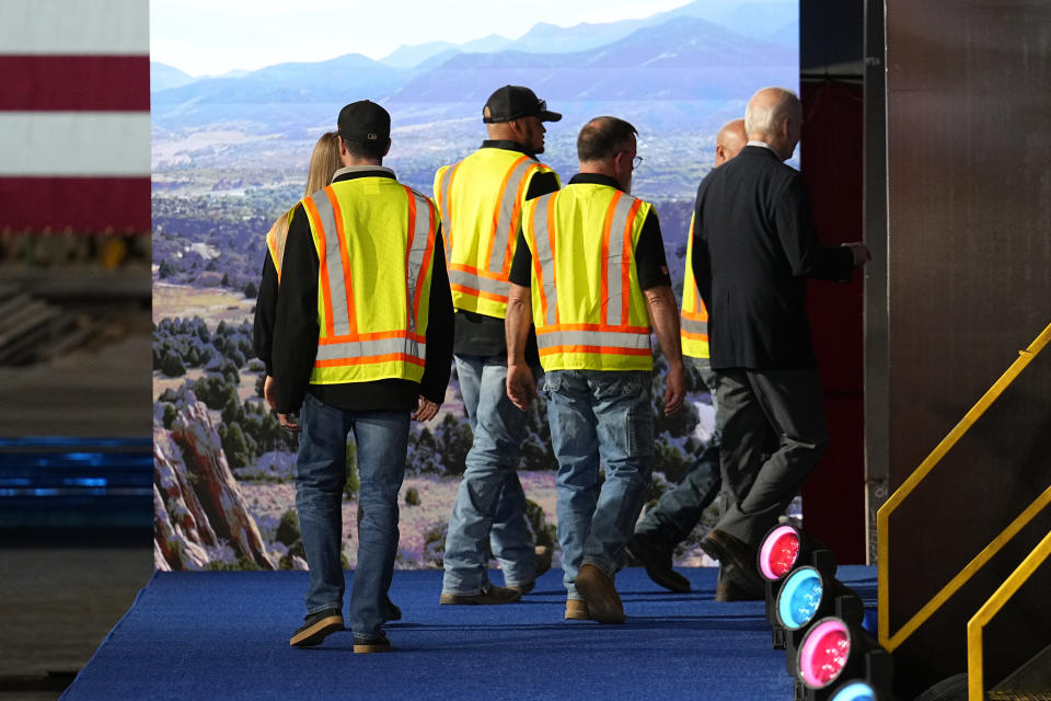 President Joe Biden walks off the stage with workers after speaking at CS Wind, Wednesday, Nov. 29, 2023, in Pueblo, Colo. (AP Photo/Jack Dempsey)