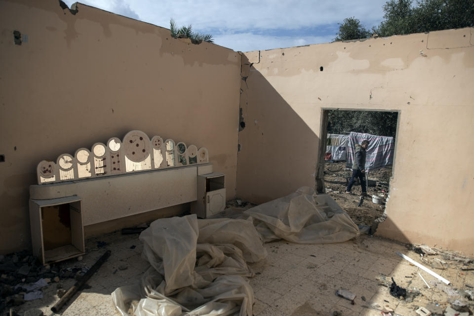 A Palestinian man walks next to a house damaged during the 11-day Gaza war in May 2021, in the town of Beit Lahiya, northern Gaza Strip, Monday, Nov. 21, 2021. The first rainstorm of winter sent water pouring into homes across the Gaza Strip that were damaged during the 11-day war in May between Israel and the Palestinian territory's militant Hamas rulers. (AP Photo/Khalil Hamra)