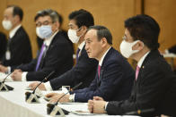 Japanese Prime Minister Yoshihide Suga, second from right, speaks during a meeting of the coronavirus infection control headquarters at his office in Tokyo Friday, Jan. 22, 2021. Suga, in a speech earlier, said the vaccine is “the clincher” in the fight against the pandemic and vowed to start vaccinations as soon as late February, when a health ministry approval of the Pfizer vaccine, the first applicant, is expected. (Kazuhiro Nogi/Pool Photo via AP)