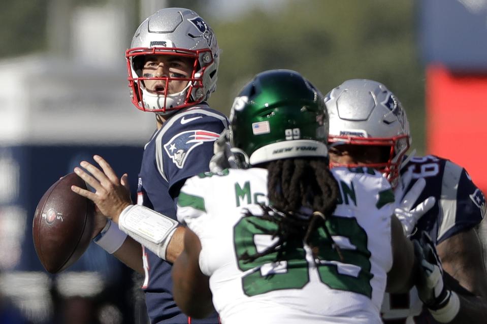 New England Patriots quarterback Jarrett Stidham, left, looks for a receiver past New York Jets defensive tackle Steve McLendon (99) in the second half of an NFL football game, Sunday, Sept. 22, 2019, in Foxborough, Mass. (AP Photo/Steven Senne)