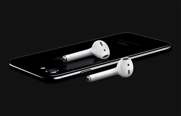 A pair of AirPods lying on an iPhone