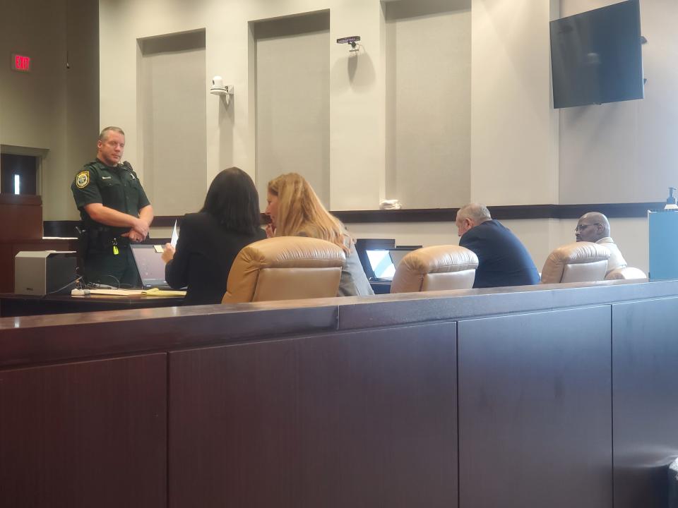 Prosecutors Barbara Beasley (seated, left) and Jennifer Lieb confer in court, with the defendant seated at the far right.