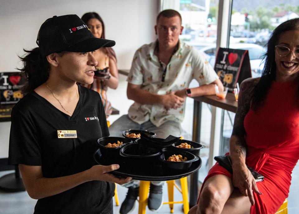 An employee offers samples to guests during a VIP grand opening celebration at I Heart Mac & Cheese in Palm Springs, Calif., Tuesday, June 28, 2022. 