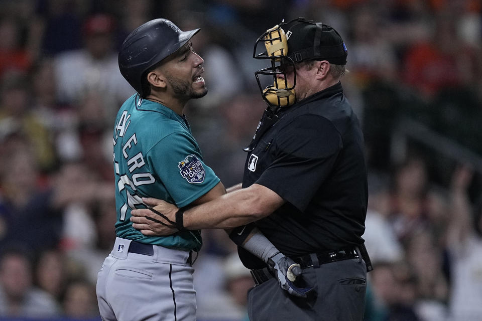 Seattle Mariners' Jose Caballero, left, yells at Houston Astros starter Framber Valdez after being hit by a pitch while umpire Bruce Dreckman, right, holds him back during the fifth inning of a baseball game, Saturday, Aug. 19, 2023, in Houston. (AP Photo/Kevin M. Cox)