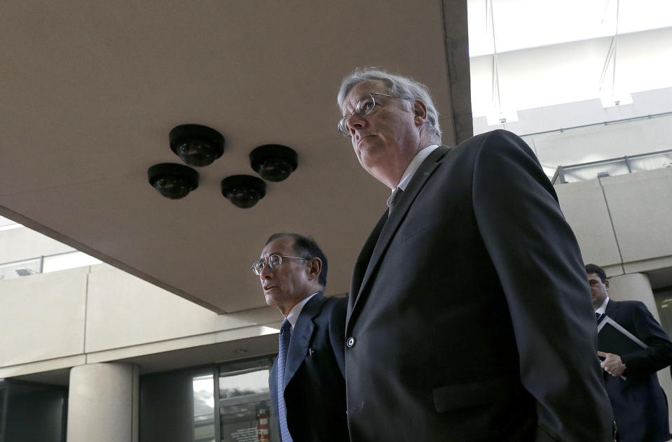 Apple attorneys Harold McElhinny, foreground, and William Lee walk to a federal courthouse in San Jose, Calif., Tuesday, April 29, 2014. The Silicon Valley court battle between Apple and Samsung is entering its final phase. Lawyers for both companies are expected to deliver closing arguments Tuesday before jurors are sent behind closed doors to determine a verdict in a closely watched trial over the ownership of smartphone technology. (AP Photo/Jeff Chiu)