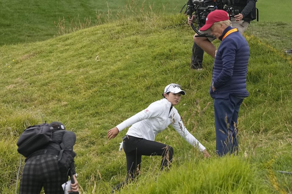 Rose Zhang, center, climbs up a hill in front of a rules official, right, while looking for her ball on the eighth hole during the first round for the U.S. Women's Open golf tournament at Pebble Beach Golf Links, Thursday, July 6, 2023, in Pebble Beach, Calif. (AP Photo/Darron Cummings)