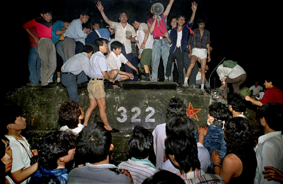 FILE - In this early June 4, 1989, file photo, civilians hold rocks as they stand on a government armored vehicle near Changan Boulevard in Beijing. Over seven weeks in 1989, student-led pro-democracy protests centered on Beijing’s Tiananmen Square became China’s greatest political upheaval since the end of the Cultural Revolution more than a decade earlier. (AP Photo/Jeff Widener, File)