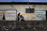 <p>An Afghan refugee man gives a haircut to a friend in an abandoned warehouse where they have taken refuge in Belgrade, Serbia, Feb. 22, 2017. (Photo: Muhammed Muheisen/AP) </p>