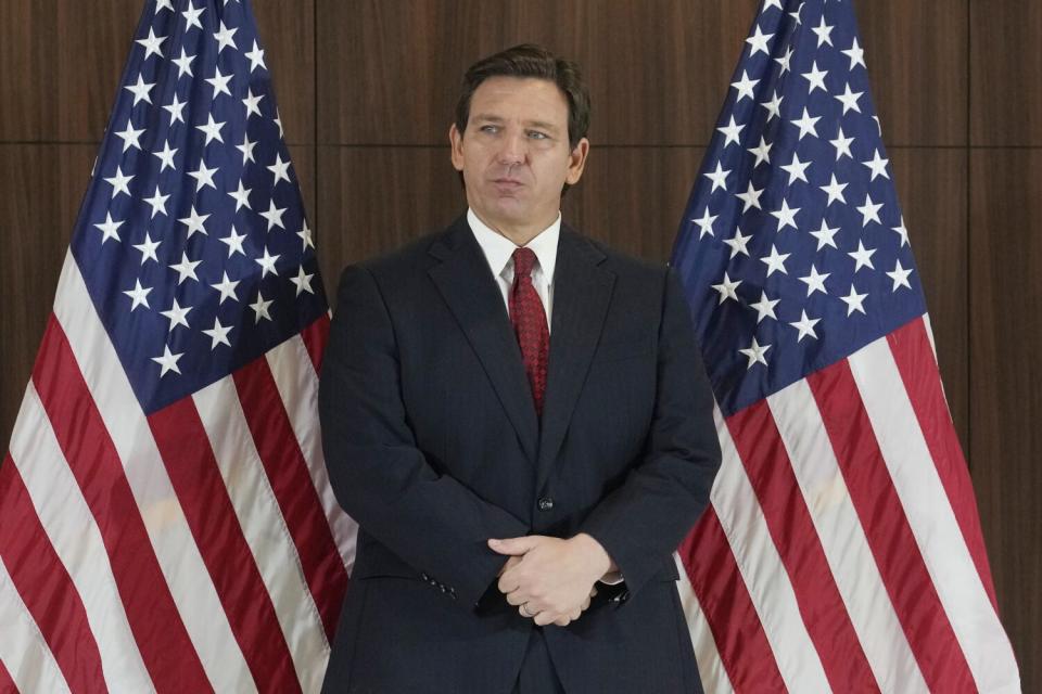 Ron DeSantis standing between two U.S. flags