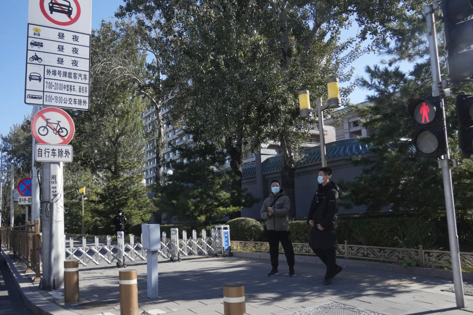 Plainclothes security personnel stand watch near a closed off sidewalk outside the Jingxi Hotel where roughly 200 members of the Central Committee are holding a plenary session in Beijing, China, Thursday, Nov. 11, 2021. China's leaders have approved a resolution on the history of the ruling Communist Party that was expected to set the stage for President Xi Jinping to extend his rule next year during a four-day meeting of its Central Committee that ended Thursday. (AP Photo/Ng Han Guan)