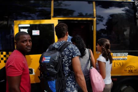 People board a public bus in Havana