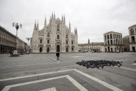 A woman crosses a nearly empty Duomo square in downtown Milan, Italy Thursday, March 12, 2020. (AP Photo/Luca Bruno)