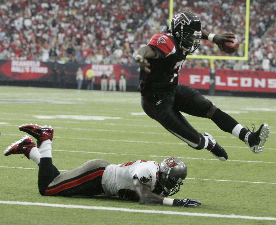 FILE - In this Sept. 17, 2006, file photo, Atlanta Falcons quarterback Michael Vick leaps over Tampa Bay Buccaneers linebacker Derrick Brooks (55) for a first quarter touchdown during an NFL football game at the Georgia Dome in Atlanta. Vick never made it to the Super Bowl with the Falcons. And his career with the team ended in disgrace. Yet no one is rooting harder for the Falcons to win their first championship. (AP Photo/John Amis, File)