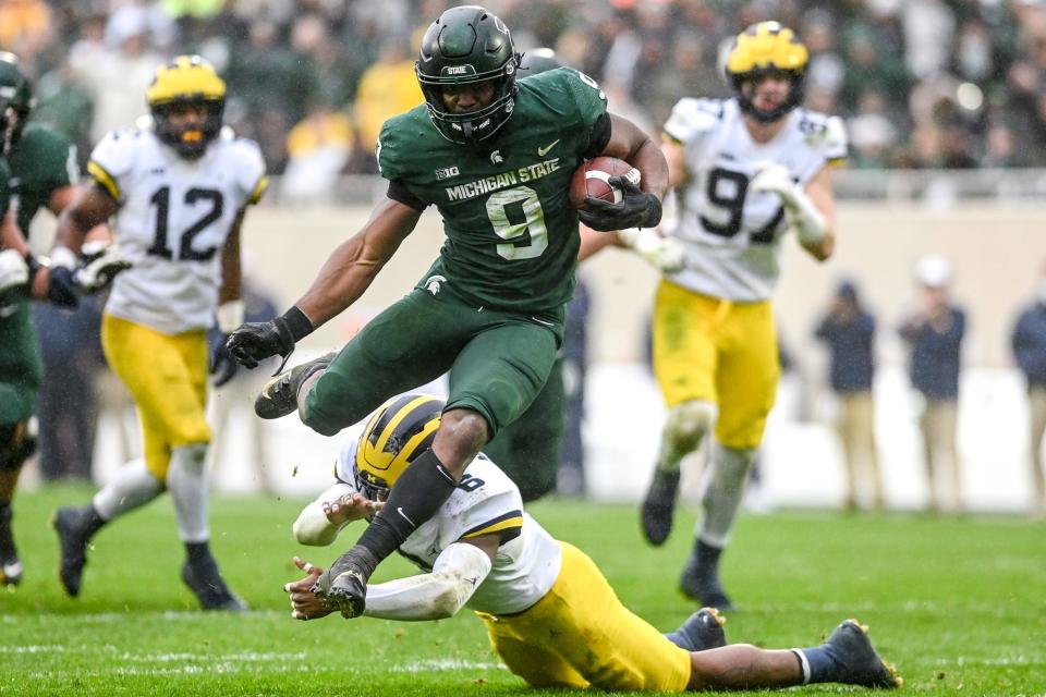 Michigan State's Kenneth Walker III avoids a tackle by Michigan's R.J. Moten during his touchdown run during the fourth quarter on Saturday, Oct. 30, 2021, at Spartan Stadium in East Lansing. Walker ran for 197 yards and five touchdowns that day.