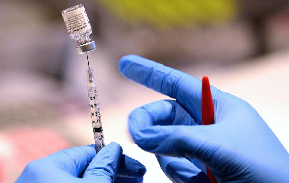 Jasmine White fills a syringe with the Pfizer-BioNTech COVID-19 vaccine at the Sheraton Charlotte Airport Hotel on Wednesday, April 14, 2021. StarMed is holding a walk-in COVID vaccine clinic with no appointments needed. StarMed is a health care provider that has primarily worked in Mecklenburg County Public Health on coronavirus testing and vaccine distribution. StarMed has received a large supply of Pfizer vaccine.