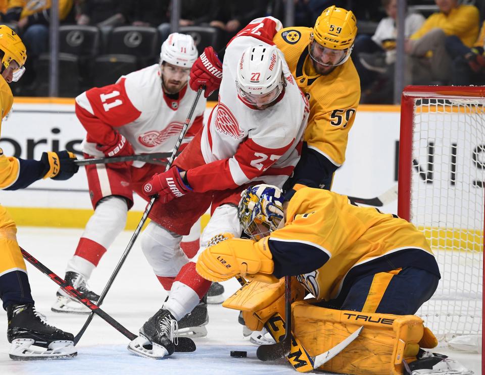 Predators goaltender Juuse Saros blocks a shot by Red Wings center Michael Rasmussen as Nashville defenseman Roman Josi assists during the second period on Saturday, Jan. 22, 2022, in Nashville, Tennessee.