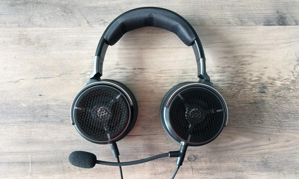 A black gaming headset, the Corsair Virtuoso Pro, rests flat down on a brown wooden table.