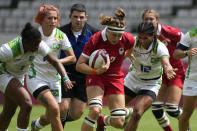 Canada's Karen Paquin, center, is pursued by Brazil's, from left, Mariana Nicolau, Luiza Campos, and Thalita da Silva Costa, as she runs on her way to scoring a try, in their women's rugby sevens match at the 2020 Summer Olympics, Thursday, July 29, 2021 in Tokyo, Japan. (AP Photo/Shuji Kajiyama)