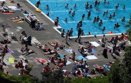 People swim and sunbathe at Brockwell Lido in London, Britain, June 26, 2018. REUTERS/Toby Melville