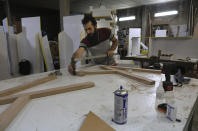 Ali Hedieloo joins pieces of wood at his furniture workshop in the southern suburbs of Tehran, Iran, Friday, July 30, 2021. New legislation proposed by Iran's hard-line lawmakers that is designed to restrict access to social media applications in Iran has sent a wave of panic through society, stirring concerns among young Iranians, social media users and business owners. Like an estimated 1 million other Iranians, Hedieloo uses social media to find customers. (AP Photo/Vahid Salemi)