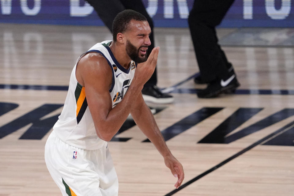 Utah Jazz's Rudy Gobert (27) reaches up after being hit in the face during play against the Denver Nuggets during the second half an NBA first round playoff basketball game, Tuesday, Sept. 1,2020, in Lake Buena Vista, Fla. (AP Photo/Mark J. Terrill)