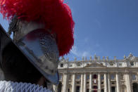 A Vatican Swiss Guard looks at Pope Francis delivering the Urbi and Orbi (Latin for to the city and to the world) blessing from the balcony of St. Peter's Basilica at the end of the Easter Mass in St. Peter's Square at the the Vatican Sunday, April 20, 2014. (AP Photo/Andrew Medichini)
