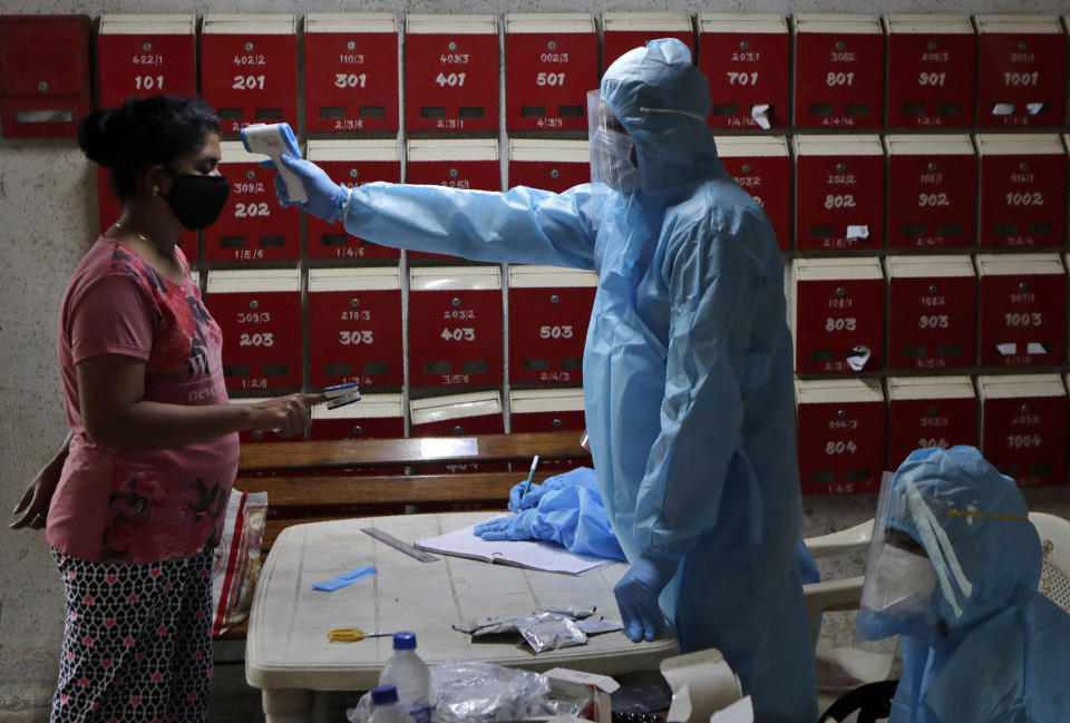 Doctor screen residents of an apartment complex for COVID-19 symptoms in Mumbai, India, Tuesday, July 28, 2020. (AP Photo/Rajanish Kakade)