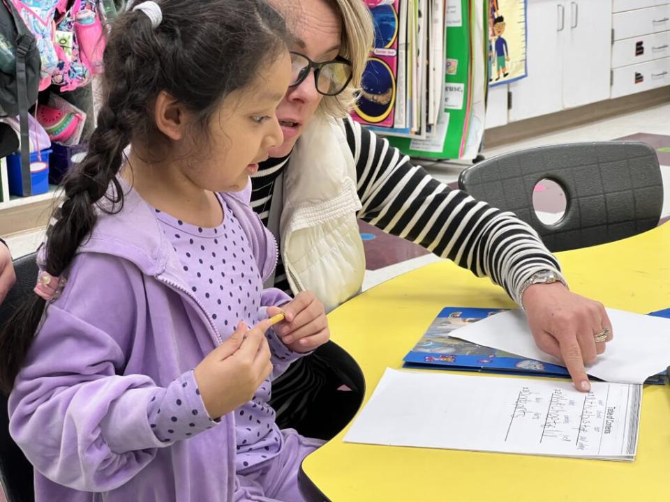 Perquimans County Schools’ Chief Academic Officer Melissa Fields checks in with a student at Perquimans Central Elementary School. Fields is leading the district’s implementation of instruction grounded in the science of reading. (Rupen Fofaria/EducationNC)