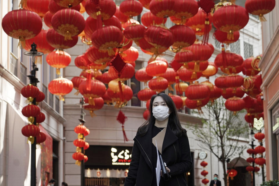 A woman wearing mask, walks on a street in Hong Kong, Thursday, Feb. 20, 2020. More than 100 Hong Kong passengers from the virus-hit cruise ship Diamond Princess arrived home from Japan early Thursday on a Cathay Pacific plane chartered by the Hong Kong government. (AP Photo/Kin Cheung)