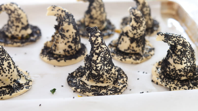 uncooked witch hat pastries on a baking sheet