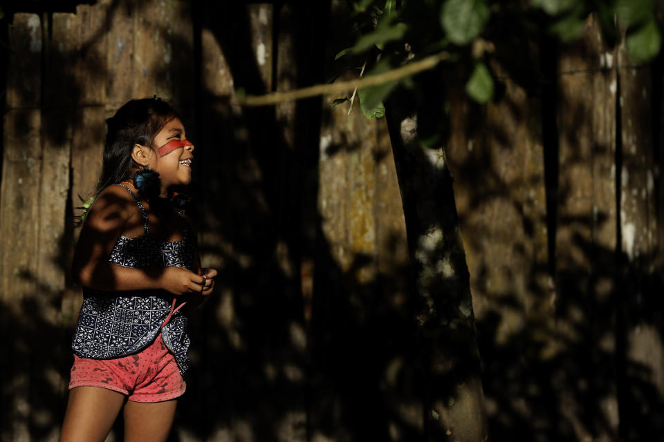 A Tenetehara Indigenous child Mayra Muxi Tembe, plays outside her home in the Alto Rio Guama Indigenous Territory, where they have enforced six months of isolation during the COVID-19 pandemic, near the city of Paragominas, state of Para, northern region of Brazil, Monday, Sept. 7, 2020. The Indigenous group, also known as Tembe, held a festival this week to celebrate and give thanks that none of their members have fallen ill with COVID-19, after closing their area off in March. (AP Photo/Eraldo Peres)